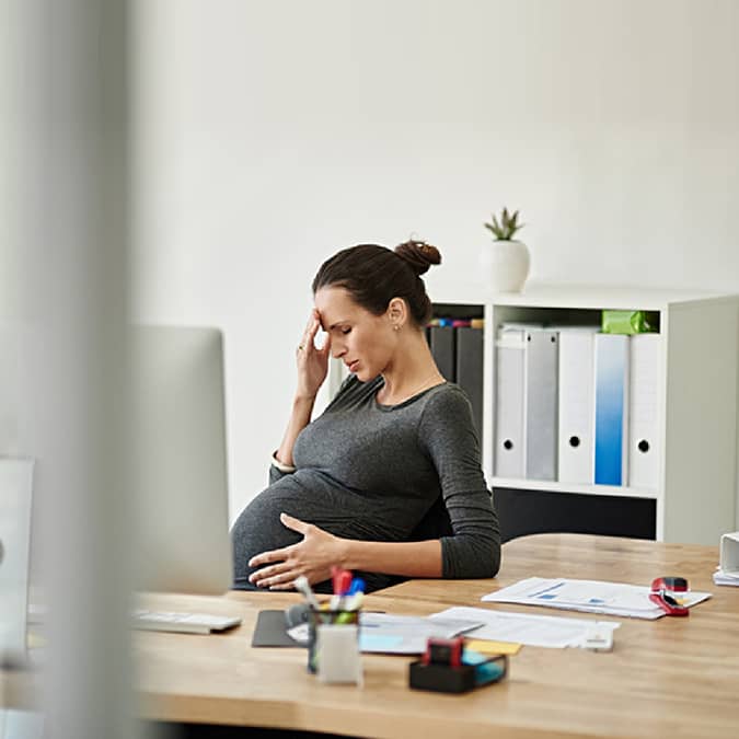 Pregnant Woman Holding Her Head in Her Hand